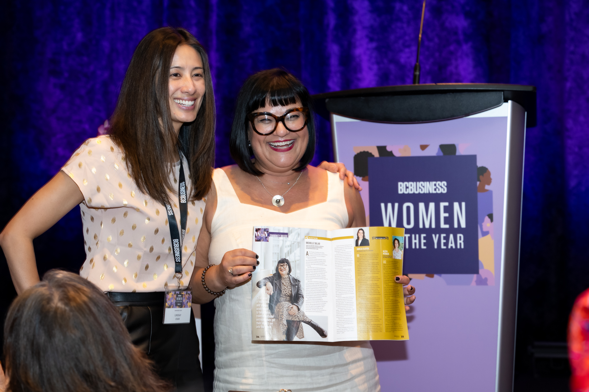 Michelle Sklar posing with her profile in the 2024 Women of the Year magazine