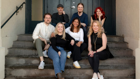 HiBoop team sitting on the steps outside a building