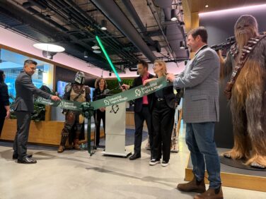 Ministers Spencer Chandra Herbert and Brenda Bailey cutting the ribbon to ILM's new location with a lightsaber