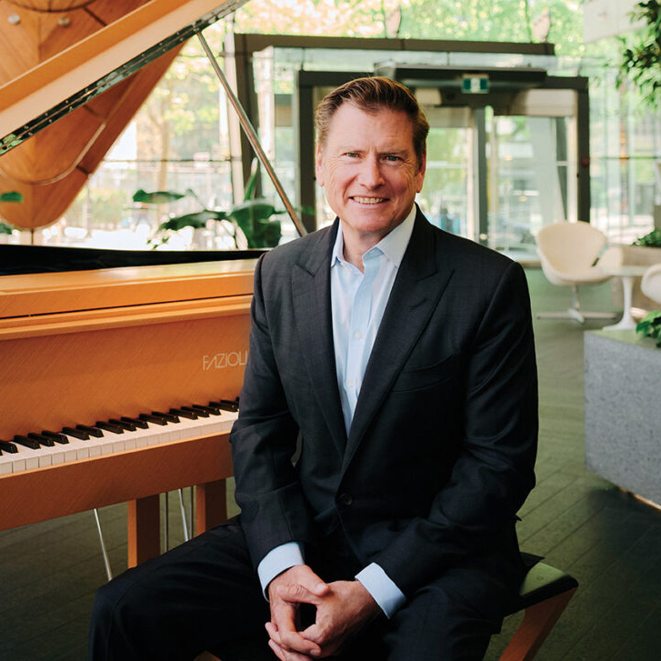 Telus president and CEO Darren Entwistle sitting by a piano