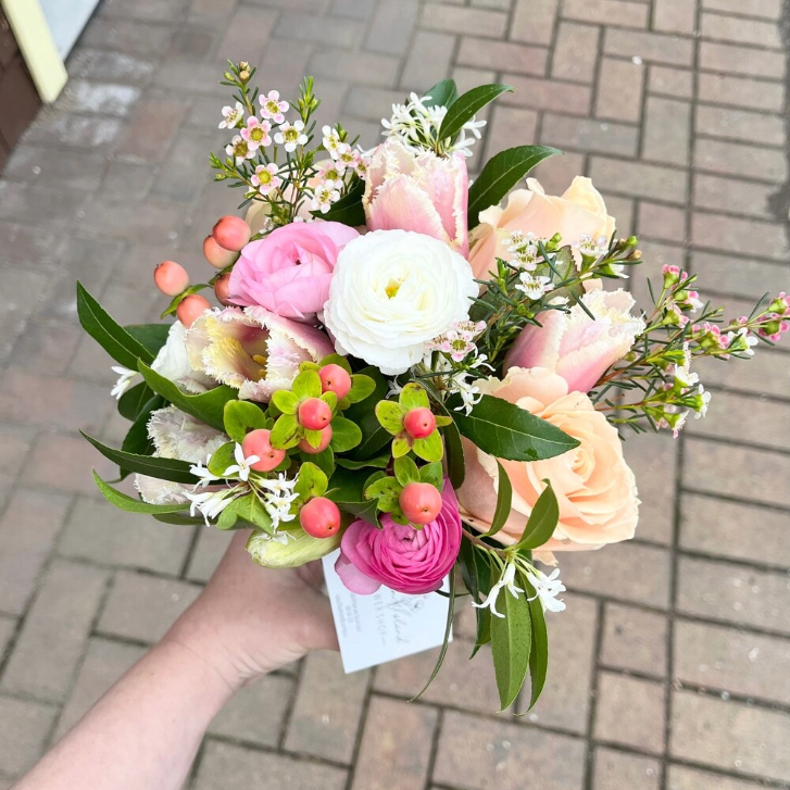 person holding a bouquet of white and pink flowers