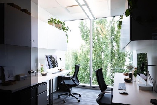 two opposite-facing desks with black chairs at Pavilion Cowork