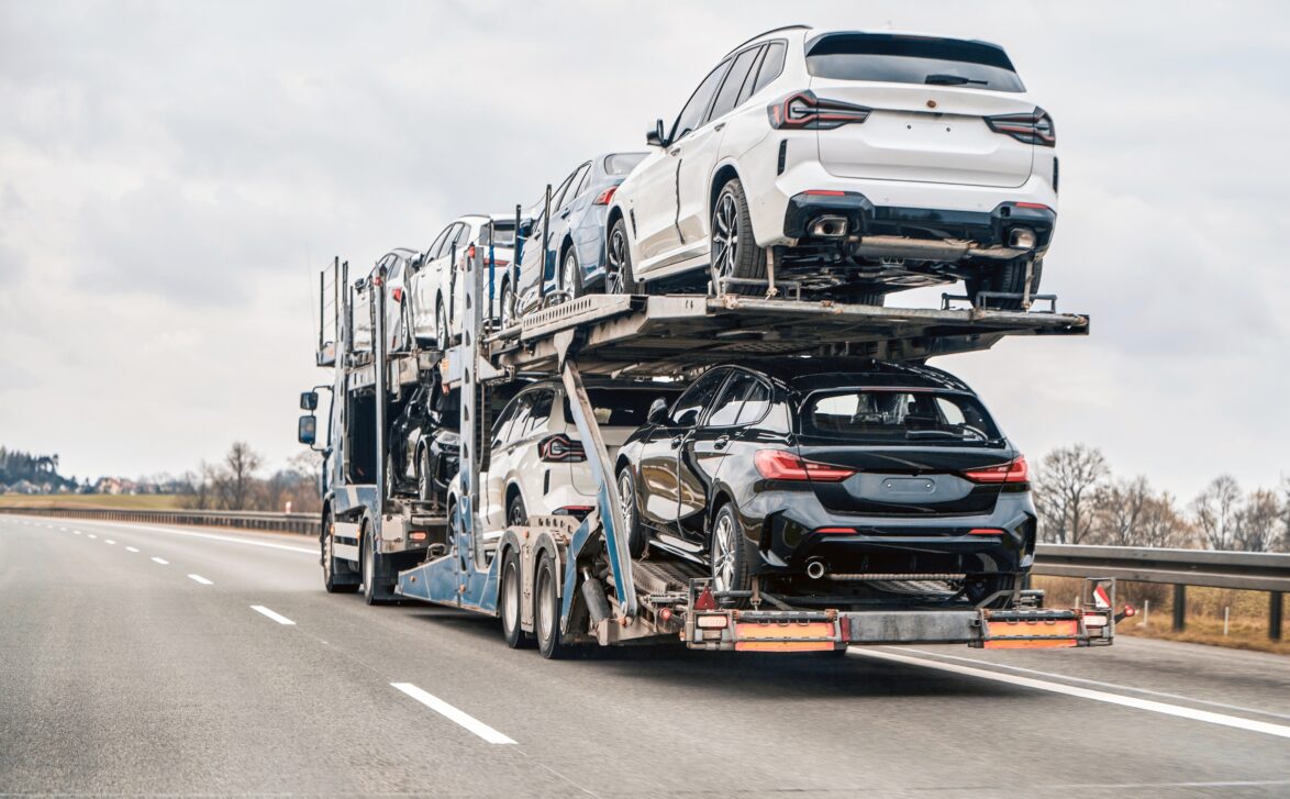 Luxury cars stacked on a transport truck driving on the road